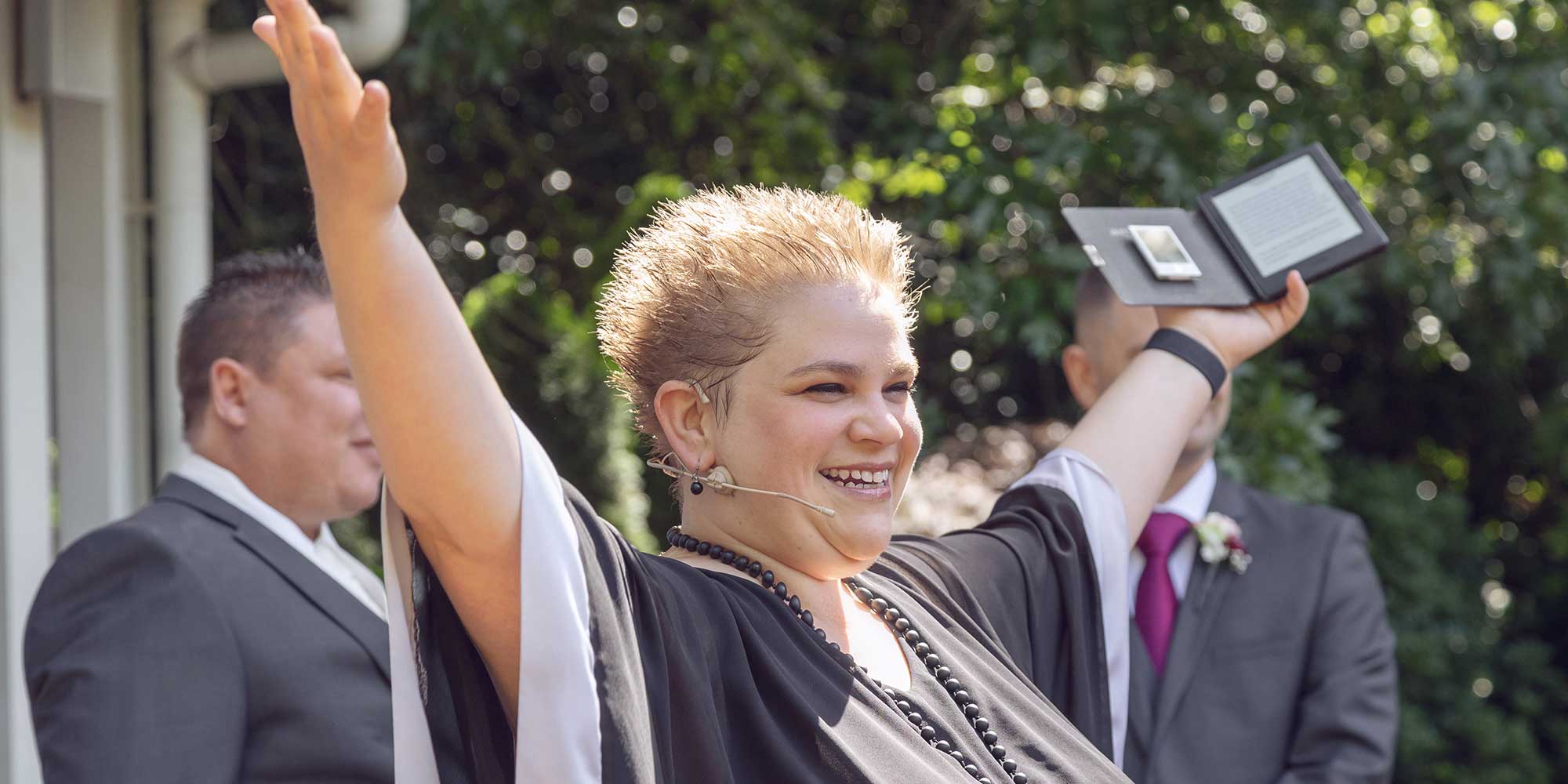 celebrant with her arms raised and a big smile